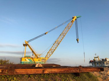 Limana parkedilmiş Crane mavnasının alacakaranlıkta mavi bir gökyüzü var..