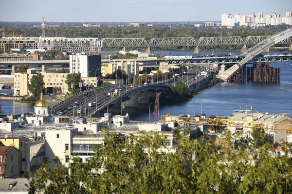 様々な橋を持つキエフ市とドニプロ川ドニエパーの旧ポディル地区の眺め。ウクライナ、2019年9月 — ストック写真