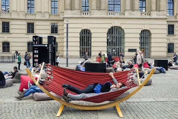 Люди отдыхают в гамаке на одной из площадей Берлина, Германия. Май 2014 года — стоковое фото