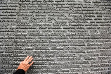 Polonyalıların isimleriyle Anıt Duvara dokunan eller, Kyiv yakınlarındaki Bykivnia 'daki Polonya askeri mezarlığında Stalinist baskıların kurbanları. Ukrayna. Eylül 2012