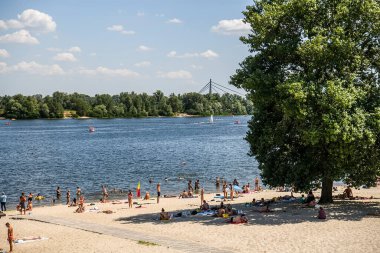 İnsanlar Ukrayna 'nın Kyiv ilçesindeki Obolon toprak seti yakınlarındaki kumlu sahilde güneşleniyor. Temmuz 2020. Yüksek kalite fotoğraf