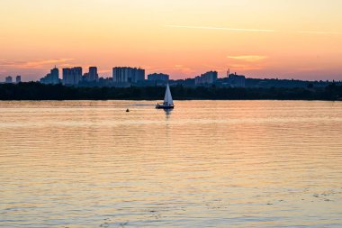 Günbatımına karşı modern binaların arkasında yelkenli. Yüksek kalite fotoğraf