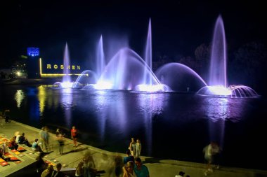Akşam manzaralı Müzikal çeşme lazer animasyonlarıyla Roshen Vinnytsia, Ukrayna 'daki Güney Buh nehrinde. 