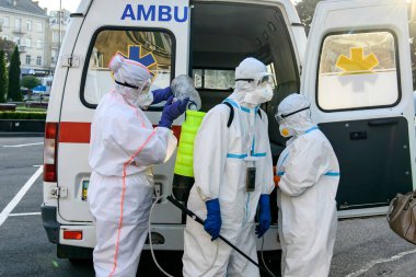 Koruyucu giysiler içindeki sağlık çalışanları, COVID-19 salgını nedeniyle Vinnytsia 'daki dezenfekte binasına geldiler.