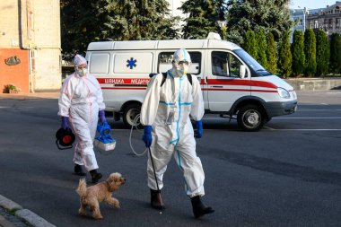 Koruyucu giysiler içindeki sağlık çalışanları, COVID-19 salgını nedeniyle Vinnytsia 'daki dezenfekte binasına geldiler.