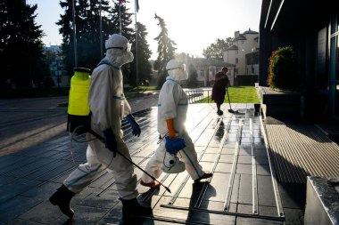 Koruyucu giysiler içindeki sağlık çalışanları, COVID-19 salgını nedeniyle Vinnytsia 'daki dezenfekte binasına geldiler.