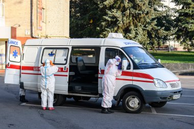 Koruyucu giysiler içindeki sağlık çalışanları, COVID-19 salgını nedeniyle Vinnytsia 'daki dezenfekte binasına geldiler.