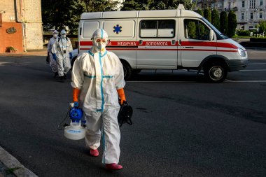 Koruyucu giysiler içindeki sağlık çalışanları, COVID-19 salgını nedeniyle Vinnytsia 'daki dezenfekte binasına geldiler.
