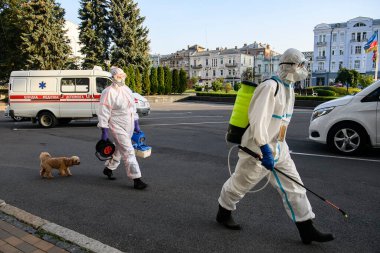 Koruyucu giysiler içindeki sağlık çalışanları, COVID-19 salgını nedeniyle Vinnytsia 'daki dezenfekte binasına geldiler.