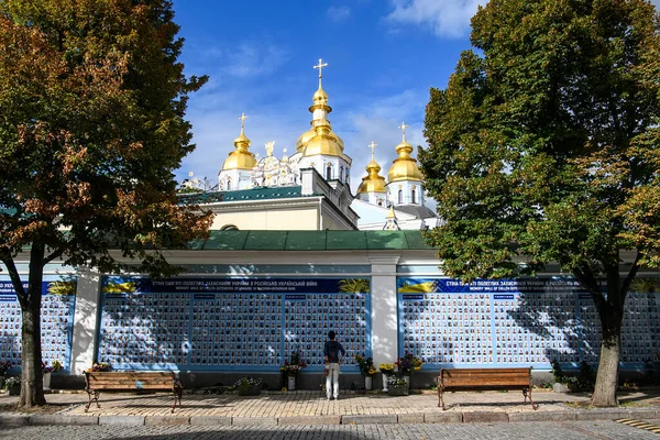 Man staat voor Memory Wall of Fallen Defenders van Oekraïne in oorlog in Oost-Oekraïne 2014-2020. Kiev, Oekraïne — Stockfoto