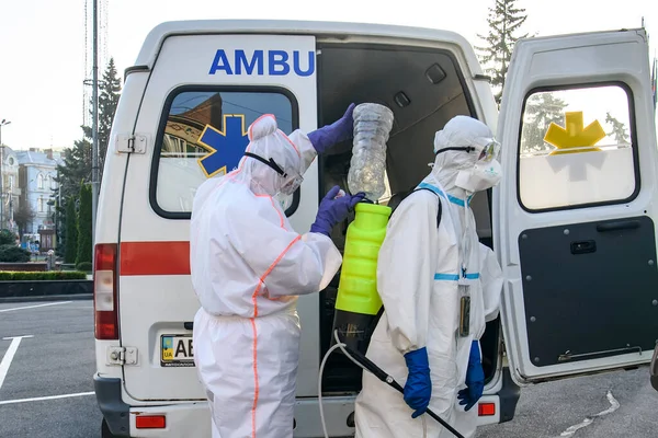 Koruyucu giysiler içindeki sağlık çalışanları, COVID-19 salgını nedeniyle Vinnytsia 'daki dezenfekte binasına geldiler.