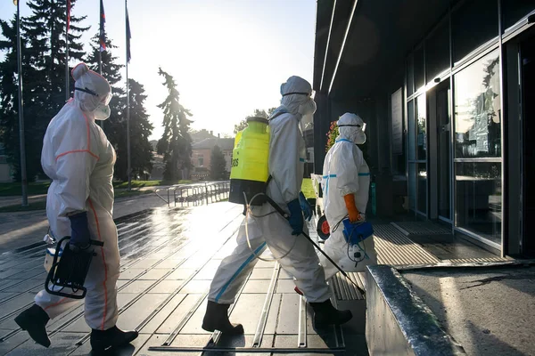 Koruyucu giysiler içindeki sağlık çalışanları, COVID-19 salgını nedeniyle Vinnytsia 'daki dezenfekte binasına geldiler.