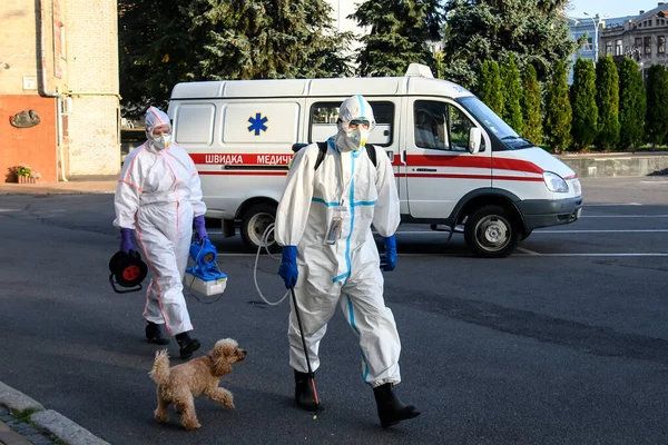 Koruyucu giysiler içindeki sağlık çalışanları, COVID-19 salgını nedeniyle Vinnytsia 'daki dezenfekte binasına geldiler.