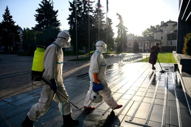 Korunaklı kıyafetler giyen sağlık çalışanları, COVID-19 salgını nedeniyle Vinnytsia 'nın merkezindeki bir binayı dezenfekte etmek için geldiler. Eylül 2020, Vinnytsia, Ukrayna.
