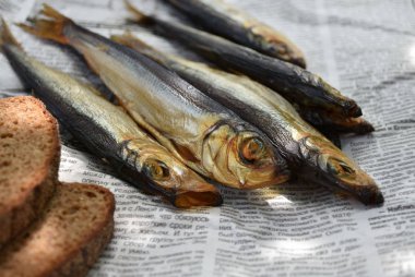 Gazetede altın füme balık ve ekmek.