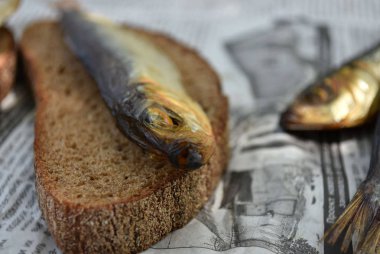 Gazetede altın füme balık. Ekmek te balık.