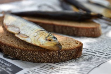 Gazetede altın füme balık. Ekmek te balık.