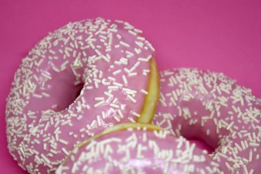 Pastel pembe arka planda kremalı çörekler. Tatlı çörekler..