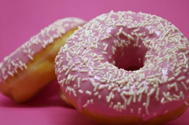 Pastel pembe arka planda kremalı çörekler. Tatlı çörekler..