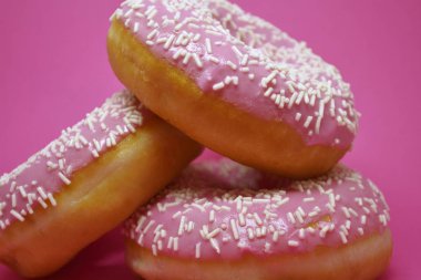 Pastel pembe arka planda kremalı çörekler. Tatlı çörekler..