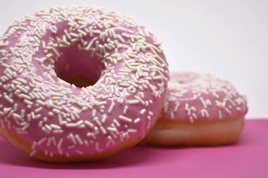 Pastel pembe arka planda kremalı çörekler. Tatlı çörekler..