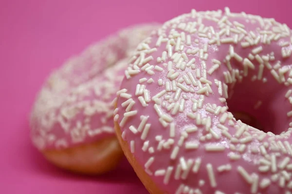 Donuts mit Sahnehäubchen auf pastellrosa Hintergrund. Süße Donuts. — Stockfoto