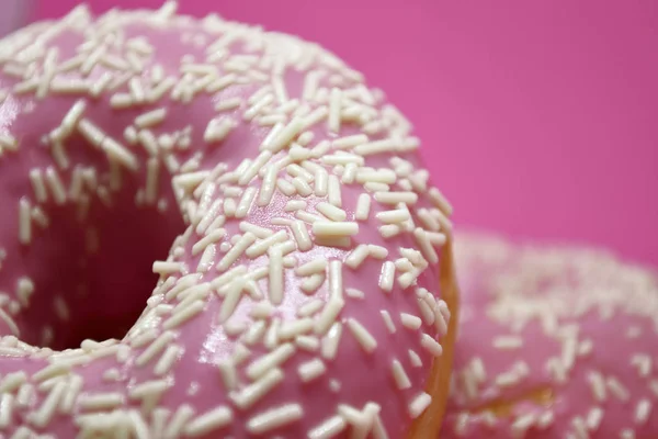 Donuts mit Sahnehäubchen auf pastellrosa Hintergrund. Süße Donuts. — Stockfoto