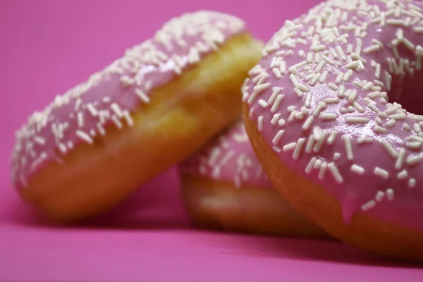 Donuts mit Sahnehäubchen auf pastellrosa Hintergrund. Süße Donuts. — Stockfoto