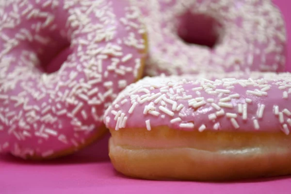 Donuts met glazuur op pastelroze achtergrond. Zoete donuts. — Stockfoto