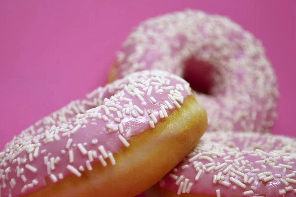 Donuts mit Sahnehäubchen auf pastellrosa Hintergrund. Süße Donuts. — Stockfoto