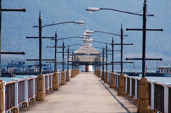 Koh Chang, Tayland arka planda deniz feneri, ağaçlar ve dağlar ile güzel iskele.