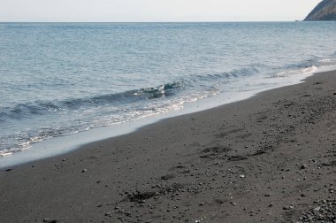 Sicilya'nın kuzey kıyısında, volkanik ada Stromboli kıyısında siyah kum plaj.