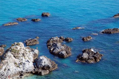 Akdeniz'in mavi suları ile kayalık kayalık kıyı şeridi.