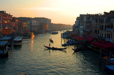 Gün batımında Venedik'teki Büyük Kanal'da romantik tekneler ve gondollar.