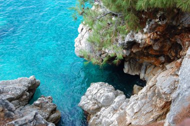  Kristal mavi su ile kıyı kayalık plajları.