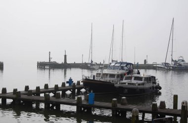 Hollanda'da sisli bir günde demirlemiş yatlar ile Hollanda limanı.