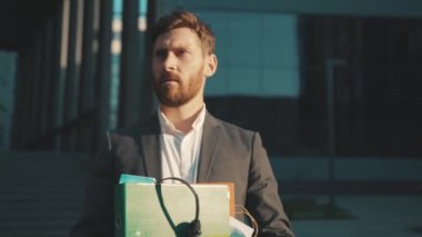 Güneş ışığında bir kutu kişisel eşyası olan genç adam Coronavirus krizi yüzünden işten atıldı. İşsiz iş dünyası ağır çekim ekonomisi.