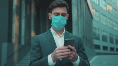 İş adamı maske takıyor. Telefon kullanıyor. Virüs koruma ilacı pandemik karantina koronavirüs krizi.
