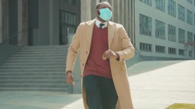 Mutlu Afrikalı Amerikalı adam maskeli gülücük dansını kaldırdı. Şehrin sokaklarında 19 koronavirüs tehlikeli enfeksiyon enfeksiyonu kaptı. Salgın korumasını yavaşça kapat.