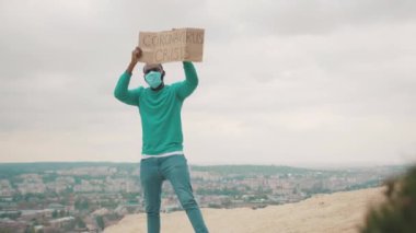 İşsiz doktor grev pankartıyla dağın tepesinde iş için savaşıyor karantina nedeniyle. Coronavirüs salgını. Küresel kriz 2020. Salgın.