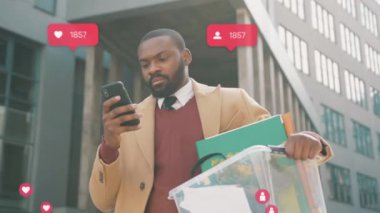 NEW YORK - 28 Mart 2020: Ciddi Afrikalı Amerikalı adam telefon kulübesinde bir kutu kişisel eşyasını kaybetti, sosyal medya simgeleri yazarken işten kovuldu, yorumcu sayacı Coronavirus krizi gibi.