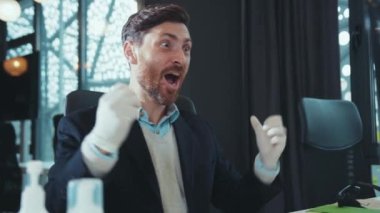 Eldivenli mutlu adamı kapat. Bilgisayar kullan. Şok hisset. Kameraya bak, modern ofis çalışanı salgın hijyenik koruma işinde gülümsüyor.