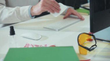 El temizleme klavyesini antiseptik sprey ve ıslak mendille dezenfekte etmek virüs antibakteriyel salgın hijyenik enfeksiyonu temiz koronavirüsü yavaşça kapatın.