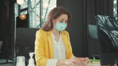 NEW YORK - 28 Mart 2020: Bilgisayar üzerinde çalışan tıbbi maskeli genç iş kadını ani baş ağrısı ve bitkin düşmüş bir ağrı hissetti. Maske korkusu. Temiz oksijen yok. Sağlık hizmetleri. Salgın.