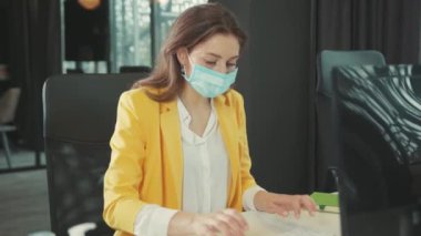 Baş ağrısı ya da oksijen yetersizliğinden muzdarip bilgisayar klavyesinde çalışan genç bir yönetici. Solunum sıkıntısı. Uzatılmış maske giymenin yan etkileri. Sağlık Hizmetleri.