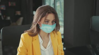 NEW YORK - 28 Mart 2020: Kadın ofis çalışanı maskesini çıkarıyor temiz hava soluyor bilgisayar projesinde çalışan temiz cerrahi eldivenler giyiyor. Sağlık, hijyen önlemleri.