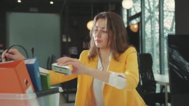 İş piyasası krizi. İşsizlik parası. Üzgün, güzel, genç bir kadın yönetici. Kişisel eşyalarını kutudan topluyor. İşini bırakıyor..