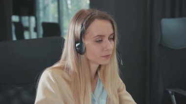 Ciddi destek yöneticisi bilgisayarda online görüntülü sohbet konferansında müşteriye danışmanlık yapıyor. Karantina sırasında uzakta çalışan güzel sarışın ofis kadını portresi.