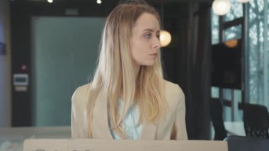 Boş ofis çalışma alanında bayrak gösteren işsiz, beyaz bir kadın var. 2020 Krizi. Karantina sırasında işsizlik. Coronavirüs salgını.