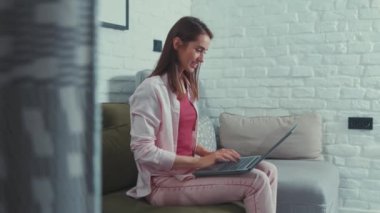 Uzak bir projede çalışan neşeli, serbest çalışan bir kadın. Güzel, mutlu, beyaz bir kız. Oturma odasında dizüstü bilgisayarda yazı yazıyor. İşinden zevk alıyor..